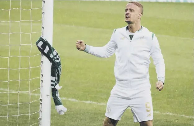  ??  ?? 0 Striker Leigh Griffiths after tying a Celtic scarf to a goalpost at Windsor Park in Belfast following the Parkhead side’s 2-0 Champions League qualifying win over Linfield.