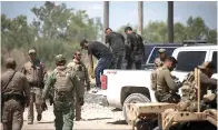  ?? (Miguel Gutierrez Jr./the Texas Tribune) ?? A group of migrants walk off a pickup truck after being apprehende­d by Department of Public Safety officers at a train depot in Spofford on Aug. 25, 2021. U.S. Border Patrol agents took into custody women and children found with the same group.