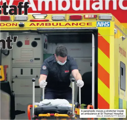  ?? HOLLIE ADAMS/GETTY IMAGES ?? A paramedic moves a stretcher inside an ambulance at St Thomas’ Hospital