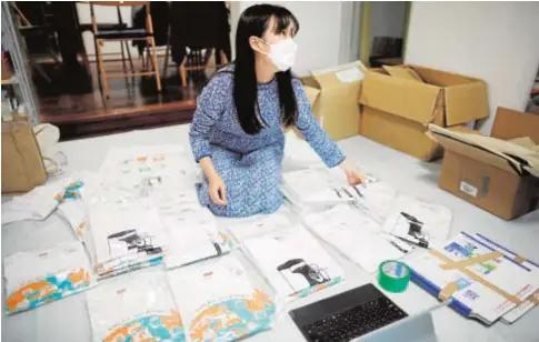  ?? // REUTERS ?? Una joven activista japonesa hace camisetas con mensajes que llaman a votar hoy en las elecciones