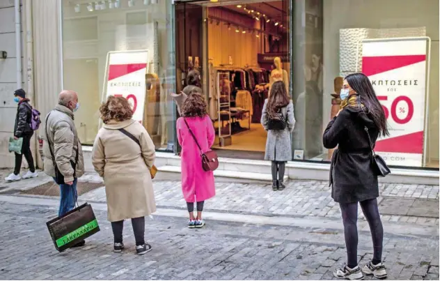  ?? Agence France-presse ?? ↑
Customers maintain social distancing before entering a shopping outlet in Athens.