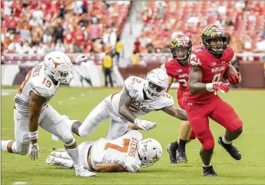  ?? RICARDO B. BRAZZIELL / AMERICAN-STATESMAN ?? Maryland running back Tayon Fleet-Davis (8) races past a trio would-be Texas tacklers, into the end zone for a touchdown Saturday in the Terrapins’ 34-29 win over the visiting Longhorns.