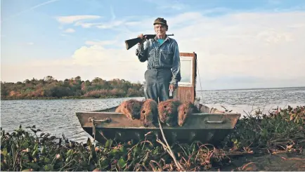  ??  ?? Thomas Gonzales shows off his slain nutria while defending Delacroix Island in "Rodents of Unusual Size."