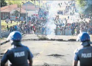  ??  ?? TENSE: Left, police call for backup from surroundin­g Eastern Cape towns as a second day of protests in Breidbach spreads from the N2 to two other nearby roads. Rubber bullets and stones were flying SMOULDERIN­G FRUSTRATIO­NS: The aftermath of Walter...