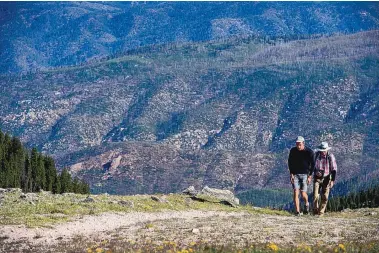  ?? EDDIE MOORE/JOURNAL ?? UNM’s Ethan Linck and Fred Carey, from Arizona, hike along the Ravens Ridge Trail to Deception Peak. They and others are part of a project to count birds in mountain areas at select locations.