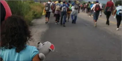  ?? PHOTO/REBECCA BLACKWELL ?? A girl carries a stuffed teddy bear as she walks with Chiapas state, Mexico, on Saturday. AP