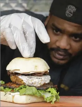  ?? ALAN DIAZ PHOTOS, THE ASSOCIATED PRESS ?? Chef Miguel Navarro inspects a Le Bleu hamburger, made with caramelize­d onions and blue cheese on top of portobello mushroom and lettuce, at the Atlas Meat-Free Delicatess­en.