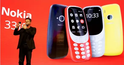  ?? — Reuters ?? arto Nummela, CeO of Nokia-hmD, holds up a Nokia 3310 device during a presentati­on ceremony at mobile World Congress in Barcelona, spain.
