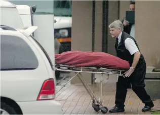  ??  ?? The body of one of six men killed in the Balmoral Tower is loaded into a van.