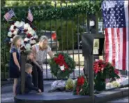  ?? DAVID J. PHILLIP — THE ASSOCIATED PRESS ?? Tiffany Utterson, right, and her children, from left to right, Ella, 11, Ian, 10 and Owen, 8, place a wreath outside the gated community entrance to the home of George H.W. Bush Sunday in Houston.