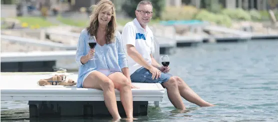 ?? DON MOLYNEAUX ?? Erhardt and Arvella Tutto enjoy a glass of wine on their dock at the Mahogany developmen­t in southeast Calgary, which can be a “hypnotizin­g” experience, says Erhardt.