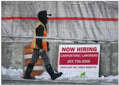  ?? (AP/Robert F. Bukaty) ?? A worker passes a hiring sign at a constructi­on site in Portland, Maine, in January.