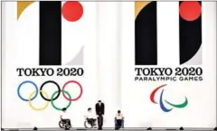  ?? AFP ?? Hammer throw gold medalist Koji Murofushi (second right) and young athletes attending a ceremony to unveil the new logos of the Tokyo 2020 Olympic (left) and Paralympic Games at the Tokyo city hall on July 24, 2015.