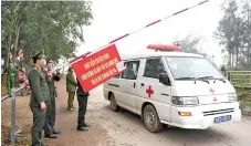  ?? — AFP photo ?? Police wearing protective facemasks amid concerns of the Covid-19 coronaviru­s allow an ambulance to pass through a checkpoint in Son Loi commune in Vinh Phuc province.