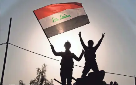  ??  ?? Members of Iraq’s federal police wave the national flag as they celebrate in Mosul in July after the government announced the “liberation” of the embattled city. FADEL SENNA/AFP/GETTY IMAGES