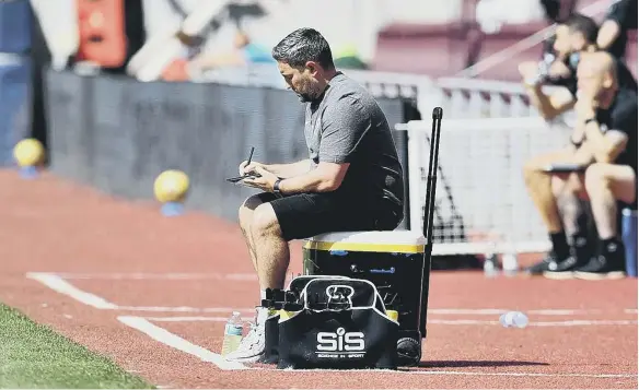  ??  ?? Sunderland head coach Lee Johnson making notes in his technical area during the pre-season friendly at Tynecastle. Picture by Frank Reid