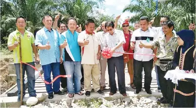  ??  ?? KURUP memotong riben sebagai gimik perasmian jambatan besi Kampung Johan Jaya.