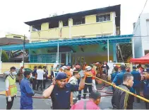  ?? AP-Yonhap ?? Police and rescue personnel work at an Islamic religious school cordoned off after a fire on the outskirts of Kuala Lumpur, Thursday. A fire at the school has killed 23 people, mostly teenagers.