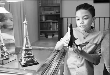  ??  ?? Romanieo Golphin Jr. examines a model of a space shuttle in his Silver Spring home. — Photos for The Washington Post by Sarah L. Voisin