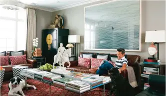  ??  ?? This undated photo provided by interior designer Vern Yip shows Yip sitting on a couch with his dogs in his home in Atlanta. — AP photos