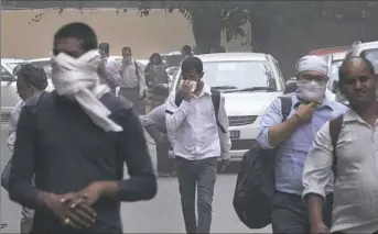  ?? Manish Swarup/Associated Press ?? People cover their noses Wednesday as a dust storm envelops New Delhi, India. Wind and rain swept parts of India overnight, causing house to collapse, toppling trees and leaving at least 125 dead.