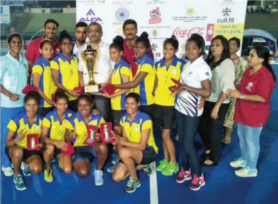  ??  ?? Jharkhand players pose with the winner’s trophy in Bengaluru on Sunday.