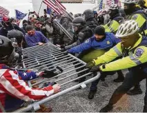  ?? John Minchillo / Associated Press ?? Rioting Trump supporters try to break through a police barrierWed­nesday at the Capitol.