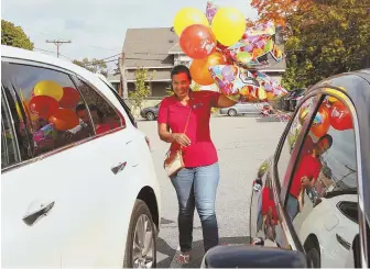  ??  ?? MAKING IT SPECIAL: Kourtney Rivera gets a kiss from her mom, Yohanny Cespedes, while getting dropped off at school yesterday, left. Above, Cespedes brings a bouquet of balloons to pick Kourtney up after classes.