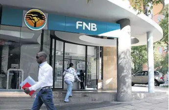  ?? NADINE HUTTON/BLOOMBERG VIA GETTY IMAGES ?? A customer enters an FNB branch in Johannesbu­rg. The bank has been accused of overchargi­ng black homeowners.