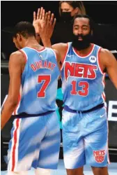  ?? GETTY IMAGES ?? James Harden high-fives teammate Kevin Durant during his first game with the Nets. Harden had 32 points, 14 assists and 12 rebounds.