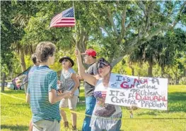  ?? JENNIFER LETT/STAFF PHOTOGRAPH­ER ?? Ari Silver, one of the tour organizers, speaks with a protester in Dreher Park on Sunday.