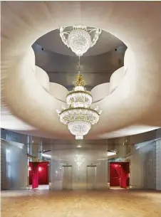  ??  ?? BELOW: A dramatic chandelier punctures the main foyer, surrounded by mirrored walls and upholstere­d balconies that echo the sensuous curves found elsewhere.