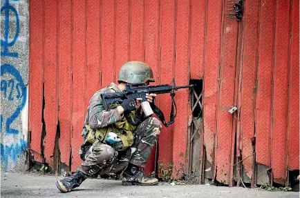  ?? PHOTO: REUTERS ?? A government soldier fighting the Maute group takes up position in Marawi City, Philippine­s.