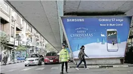  ??  ?? CAIRO: A traffic police officer stands in front of an advertisem­ent on Christmas day.