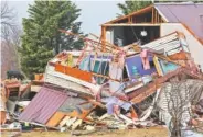  ?? STAFF FILE PHOTO BY DAN HENRY ?? Jackie Allday (top floor) helps her friend Kaylan Brown scavenge for clothing in what is left of the Browns’ residence after a tornado destroyed the Ider, Ala., home in November.