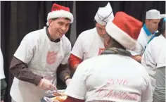  ??  ?? Gov. Scott Walker dishes out food while volunteeri­ng Sunday at the Salvation Army Christmas Family Feast.