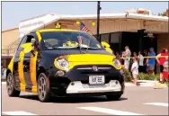  ?? Photo by Grace Nowak ?? Mary Bourn, of Noel, Mo., and her “Hum Bee” attract many admiring glances as they make their way down the Gravette Day parade route. The Hum Bee, an allelectri­c Fiat, won the trophy for best car in the parade. Mary is well-known to many Gravette residents as a member of the Old Town String Band, which entertains in the area.