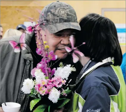  ?? DAVE MILNE/ SPECIAL TO THE VANCOUVER SUN ?? Helen Cunningham hugs Marvin Charlie, brother of missing mill worker Carl Charlie on Monday in Burns Lake. The fl owers she gave him with were not only in sympathy for his brother but in memory of his step- daughter, murdered one year ago.