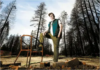  ?? RICH PEDRONCELL­I/AP ?? Camp Fire survivor Zachary Byrd poses where his home was located before it was destroyed by last year’s wildfire.