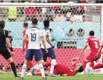  ?? — AFP ?? England’s Bukayo Saka (C) scores past Iran’s goalkeeper Hossein Hosseini at the Khalifa Internatio­nal Stadium in Doha.