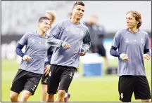  ??  ?? Real Madrid’s Cristiano Ronaldo (center), Luka Modric (right), and James Rodriguez warm up with team mates during a training session prior to the Champions League quarter-final first leg soccer match between FC Bayern Munich and Real Madrid, in Munich,...