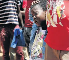  ?? PHOTOS: SANDILE NDLOVU ?? Mulweli Nefale, 6, reacts to the heat on her birthday while queuing with her parents to register her for Grade 1 at the Johannesbu­rg central district offices in Soweto.