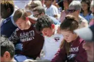  ?? GERALD HERBERT — ASSOCIATED PRESS ?? Ryan Schroy, 15, left, Dylan O’Neill, 15, and Kaedree Knox, 15, right, embrace each other during a vigil Thursday at the Parkland Baptist Church in Parkland, Fla.