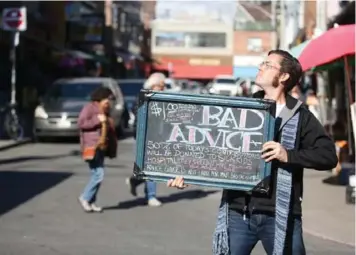  ?? VINCE TALOTTA/TORONTO STAR ?? With a background in finance, Ryan Sadler’s latest endeavour involves carrying a sign that offers lousy advice for $1.