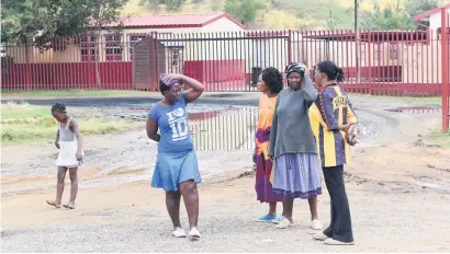  ?? Picture: Nigel Sibanda ?? NO ANSWER. Parents outside Durban Deep Primary School gates in Roodepoort yesterday after it was closed due to allegation­s of water contaminat­ion. Community members protested.