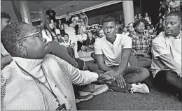  ?? JEAN PIERI/PIONEER PRESS ?? Assistant professor Aura Wharton-Beck, left, clasps hands with freshman Kevyn Perkins before a recent protest over a racial slur at the University of St. Thomas in St. Paul, Minn.