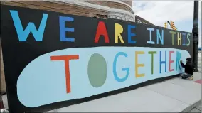  ?? TONY DEJAK — THE ASSOCIATED PRESS ?? Erin Guido finishes painting the slogan “We are in this together!” April 10at a constructi­on site during the coronaviru­s outbreak in Cleveland.