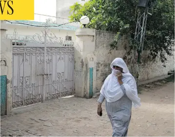  ?? B.K. BANGASH / THE ASSOCIATED PRESS ?? A Pakistani woman walks past the childhood home of London Bridge attack suspect Khuram Butt, in Jhelum, Pakistan, on Tuesday. Butt moved to Britain, working for Transport of London as a service clerk and Kentucky Fried Chicken and where he embraced...