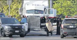  ?? AP PHOTO ?? San Antonio police officers investigat­e the scene where eight people were found dead in a tractor-trailer loaded with at least 30 others outside a Walmart store in stifling summer heat in what police are calling a horrific human traffickin­g case,...