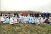  ?? ANTONINO DURSO / LAPRESSE VIA AP ?? Rescued migrants sit covered in blankets at a beach near Cutro, southern Italy on Sunday.